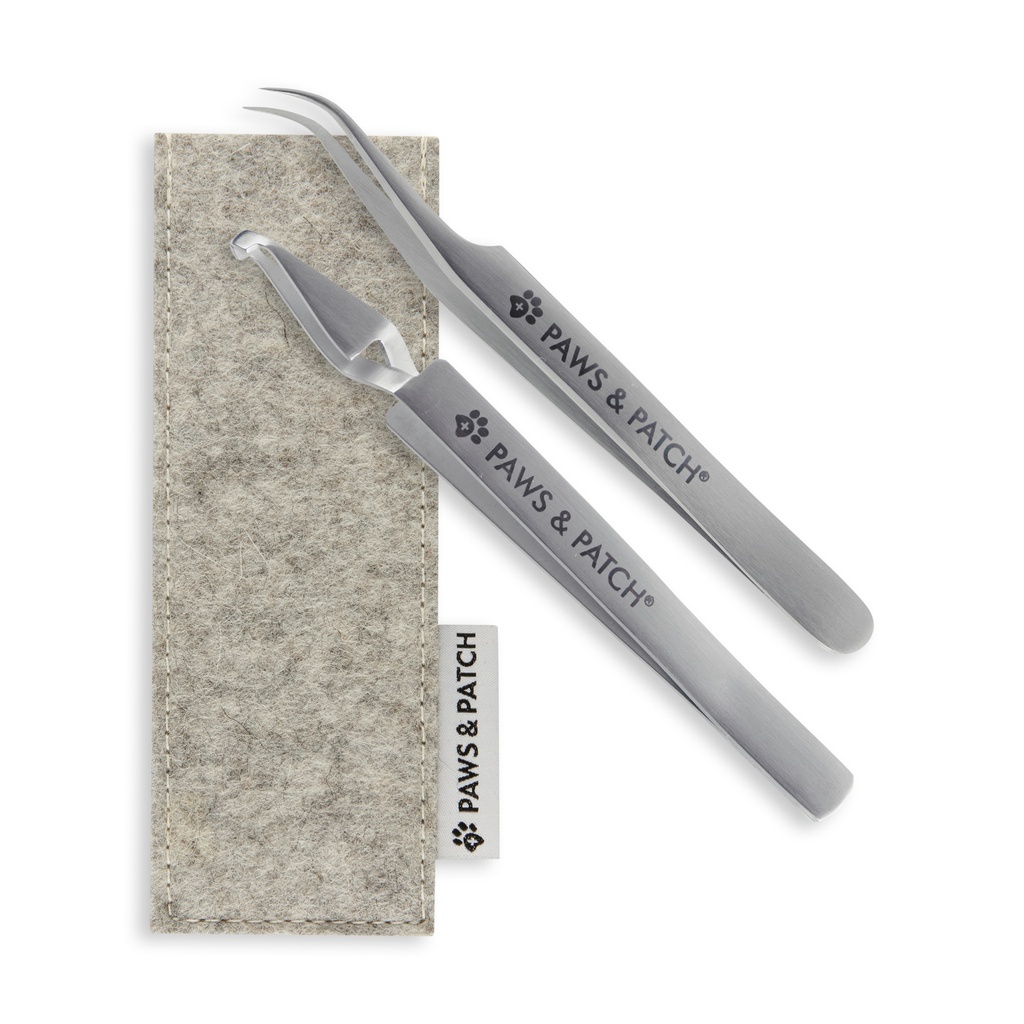 Zwei verschiedene Zeckenzangen aus Edelstahl auf grauem Filzetui liegend