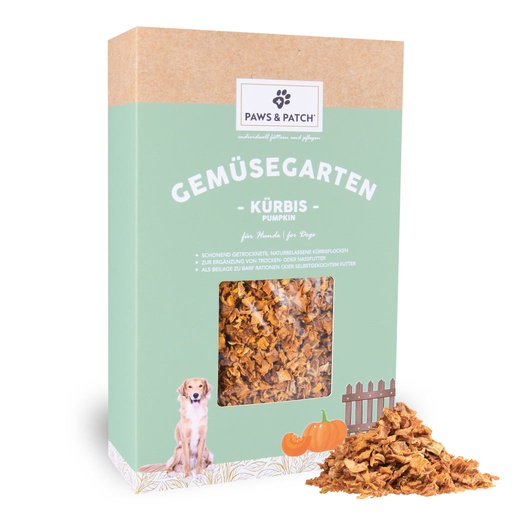 Hellgründe Verpackung aus Pappe mit Sichtfenster, das Kürbisflocken zeigt - davor ein Häufchen ausgepackte Kürbisflocken