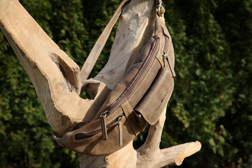 Bauchtasche aus robustem Leder um eine Wurzel geschlungen