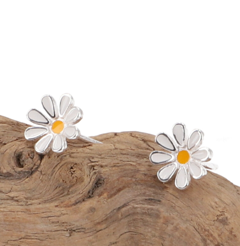 Ohrstecker in Blumenform auf Holz liegend